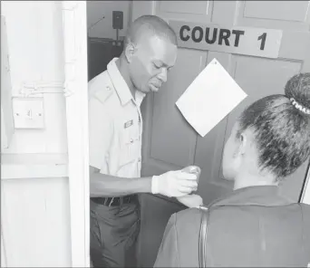  ??  ?? A member of the public receiving sanitiser on her hand before entering the courtroom