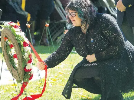  ?? BRUCE EDWARDS/ EDMONTON JOURNAL ?? Claire Woodall, the widow of slain Edmonton Police Service Const. Daniel Woodall, lays the first wreath during the Provincial Police and Peace Officer Memorial Day event on the legislatur­e grounds in Edmonton on Sunday.