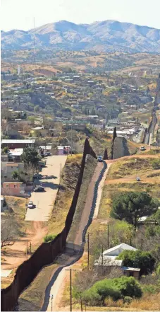  ?? DAVID WALLACE, THE ARIZONA REPUBLIC ?? The 20-foot-tall steel fence in place now cuts through neighborho­ods on both sides of the Nogales divide.