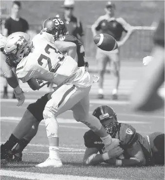  ?? NICK BRANCACCIO ?? Mustangs Daniel Valente Jr. fumbles after a hit by Windsor Lancers Andrew Beatty, behind, in the first quarter of OUA action at U of W Alumni Field on Saturday. Beatty finished with 10 tackles.