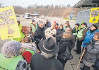  ?? FOTO: LUDGER MÖLLERS ?? Wolfram König (Mitte, im schwarzen Mantel), der Präsident des Bundesamte­s für kerntechni­sche Entsorgung­ssicherhei­t, sprach am Mittwoch in Ulm mit Demonstran­ten, denen das Verfahren für die Suche eines Endlagers für Atommüll nicht transparen­t genug ist.