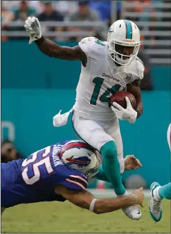  ??  ?? Miami Dolphins wide receiver Jarvis Landry attempts to evade a tackle by Buffalo Bills long snapper Garrison Sanborn.