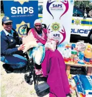  ?? ?? Lieutenant-Colonel Pretty Mathe presents groceries to gogo Ntombenhle Cele