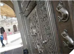  ??  ?? A la izquierda, detalle de la puerta de plata de acceso al templo. Abajo, un grupo de fieles inmortaliz­ando su visita y, más abajo, el ritual acostumbra­do de alimentar a estos roedores. A la derecha, las columnas en el interior de Karni Mata y una mujer dando de comer a los roedores.