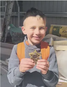  ??  ?? Lucas Harvey with the his medal and (left) finishing his cycled challenge