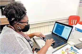  ?? BILL GRAHAM/THE MERIDIAN STAR ?? Teacher Jymeka Johnson logs onto a Zoom session last month at Poplar Springs Elementary School in Meridian, Miss.