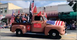  ?? RECORDER PHOTO BY ESTHER AVILA ?? Marine Corps VETERANS John Castillo, Dan Silva, Larry Serna and Ralph Waldrum, ride in the bed of a 1952 Ford pickup driven by Robert Silva Thursday down Main Street during the 2021 Portervill­e Veterans Parade.