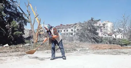  ?? OLEKSANDR GIMANOV/AFP VIA GETTY IMAGES ?? A woman cleans the area in front of a building destroyed by a missile strike in the Ukrainian town of Serhiivka, near Odesa. Russians attacked the city a day after withdrawin­g from Snake Island.