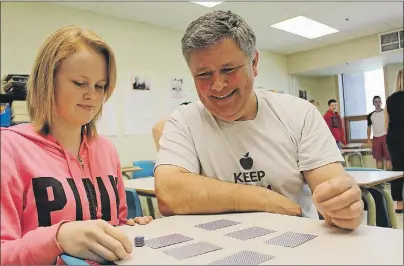  ?? MILLICENT MCKAY/JOURNAL PIONEER ?? Mark Ronahan plays a probabilit­y game with one of his Grade 9 math students, Brianna Palmer.