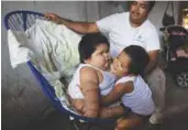  ?? AFPPIX ?? Mario (bottom) hugs his brother Luis as their father looks on at their home in Tecoman, Colima state, Mexico on Nov 8.