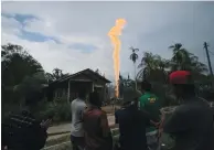  ??  ?? LOCAL RESIDENTS watch yesterday as an illegal oil well burns in Ranto Peureulak, Aceh Province, Indonesia.