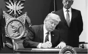  ?? PHOTO: REUTERS ?? US President Donald Trump signs a revised executive order for a US travel ban, in Washington on Monday