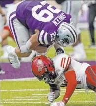  ?? The Associated Press ?? Charlie Riedel
Arkansas State safety Antonio Fletcher upends Kansas State fullback Jax Dineen in the second half of the Red Wolves’ 35-31 win Saturday at Bill Snyder Family Stadium.