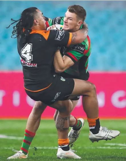  ?? Picture: GETTY IMAGES ?? Wests Tigers centre Mahe Fonua wraps up Souths winger Campbell Graham last night.