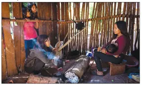  ?? ?? Margarita Mendez (front left) drinks mate as her friend Cristina Chamorro breastfeed­s in a a home’s outdoor kitchen in the Guaraní Indigenous community of Kaaguy Pora II, on the outskirts of Andresito, the center of the world’s maté production. Yerba mate is found in almost every Argentine household.