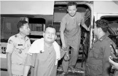  ??  ?? Suth Vanny (centre left) and Mao Hoeun (centre right) are escorted by police officials at Phnom Penh’s municipal court. — AFP photo