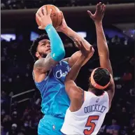 ?? John Minchillo / Associated Press ?? Hornets forward Miles Bridges, left, shoots against Knicks guard Immanuel Quickley on Monday.