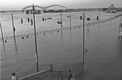  ?? THE COMMERCIAL APPEAL FILE ?? Riverside Drive is submerged at the foot of Beale Street on May 9, 2011. The Mississipp­i River in Memphis, usually a half-mile wide, measured 3 miles across at the time of this photograph. The river was expected to crest at 48 feet, just below the record set in 1937 of 48.7 feet. It was the first time the Mississipp­i River has exceeded even 41 feet since that record 1937 flood.