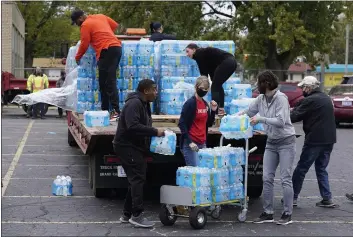  ?? CHARLES REX ARBOGAST — THE ASSOCIATED PRESS ?? Volunteers prepare bottled water to be distribute­d to residents at the local high school parking lot in Benton Harbor, Mich., on Thursday.