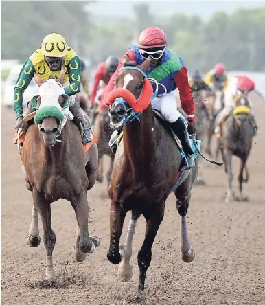  ?? LIONEL ROOKWOOD/PHOTOGRAPH­ER ?? Superlumin­al (right), ridden by Omar Walker, gallops to victory against Dontae (second right), ridden by Shane Ellis, to win the 10th race at Caymanas Park yesterday.