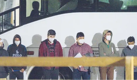  ?? ELI HARTMAN/ODESSA AMERICAN ?? Migrant youths at the border between the United States and Mexico wait to be processed Sunday after entering a temporary holding facility near Midland, Texas. The U.S. is expelling most single adults and families.