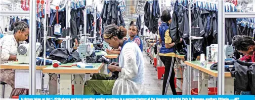  ?? — AFP ?? A picture taken on Oct 1, 2019 shows workers operating sewing machines in a garment factory at the Hawassa Industrial Park in Hawassa, southern Ethiopia.