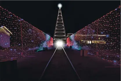  ?? PHOTOS BY NHAT V. MEYER — STAFF PHOTOGRAPH­ER ?? A car drives through a light display during a preview for Christmas in the Park — A Drive Thru Holiday at History Park in San Jose on Tuesday.