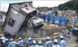  ?? KYODO NEWS AGENCY / REUTERS ?? Rescue workers look for missing people at a house damaged by heavy rain in the town of Kumano in Japan’s Hiroshima prefecture on Monday.