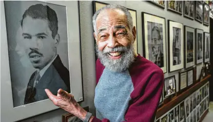  ?? Brett Coomer / Staff photograph­er ?? Thomas Freeman, showing a photo of himself from the 1950s in the hallway outside his office at TSU, turns 100 Thursday.