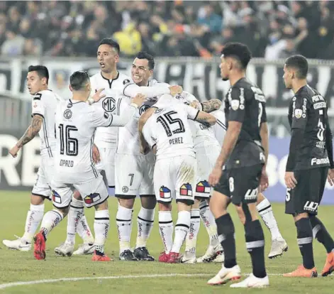  ??  ?? ► Colo Colo se abraza alrededor de Carmona, autor del único gol del partido.