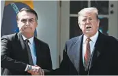  ?? MARK WILSON/GETTY ?? Brazilian President Jair Bolsonaro, left, and President Trump shake hands after a joint news conference.