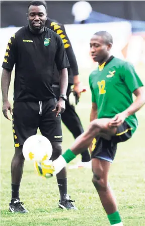  ??  ?? In this file photo from October 15, 2012, then national head coach Theodore Whitmore (left) looks on as midfielder Demar Phillips juggles a ball during a Jamaica training session at the National Stadium.