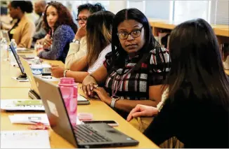  ?? CHRISTINA MATACOTTA / CHRISTINA.MATACOTTA@AJC.COM ?? Shaketha Blankenshi­p and Tina Pellechia (right), counselors for Atlanta Public Schools, confer during a training session for city school system’s guidance counselors on how to use new computer-based tools at Jackson High School. One digital tool developed by Atlanta Public Schools and other groups helps students find colleges best suited to their needs.