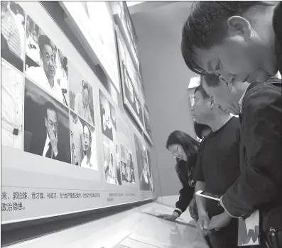  ??  ?? Visitors read confession­s by corrupt officials at an exhibition showcasing China’s progress over the last five years in Beijing on Friday. Pictures of fallen officials, including Bo Xilai, Ling Jihua and Sun Zhengcai, were displayed at the exhibition.