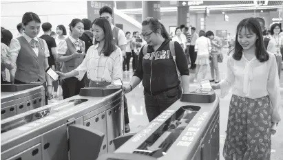  ??  ?? 今年5月8日，乘客在深圳地铁福田站­用手机扫码乘车 新华社图