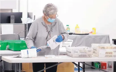  ?? ADOLPHE PIERRE-LOUIS/JOURNAL ?? Roselee Tatum processes absentee ballots at the Bernalillo County Voting Machine Warehouse on Tuesday. In Bernalillo County, over 122,000 people, or about 38% of all eligible voters, requested absentee ballots, and 98,861 ultimately submitted them.