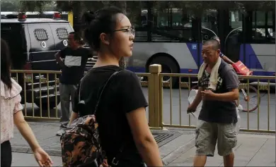  ?? AP PHOTO/ANDY WONG ?? In this July 3, photo, Ren Liping (center) looks for the direction to the police headquarte­rs to file her petition to have her rape allegation case re-examined in Beijing. Chinese graduate student Ren has spent the past year filing lawsuits and attempting to protest authoritie­s in the coastal city of Qingdao for what she says was their mishandlin­g of her rape allegation.