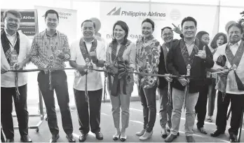  ?? PAL CORPCOM ?? DAVAO-SIARGAO INAUGURAL. As part of the send-off ceremonies for the maiden journey of the PAL Davao-Siargao flight, a ribbon cutting ceremony was held led by Department of Tourism Secretary Wanda Teo (middle holding bouquet). Also in photo are (from...