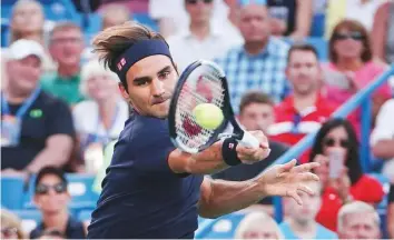  ?? AP ?? Roger Federer hits a forehand return to Peter Gojowcyzk of Germany in the second round of the Western &amp; Southern Open in Mason on Tuesday. The Swiss ace won in straight sets.