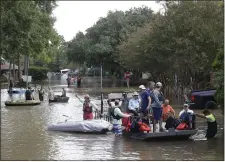  ?? THOMAS B. SHEA — GETTY IMAGES ?? Families evacuate from their homes in Lakeside Estate in Houston on Wednesday. Social media played a vital role in aiding hurricane victims.