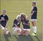  ??  ?? The Chicago Red Stars’ Julie Ertz holds Casey Short as they kneel while Rachel Hill puts her hand on Short’s shoulder during the playing of the national anthem before an NWSL Challenge Cup game last week.