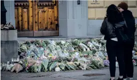  ?? BILD: JOHAN NILSSON ?? Mars tidigare i år: En strid ström av sörjande passerar förbi de blommor, ljus och hälsningar som placerats på trappan vid huvudingån­gen till Malmö latinskola efter morden. Arkivbild.