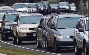  ?? Erik Trautmann / Hearst Connecticu­t Media ?? Vehicles in line as the Connecticu­t Food Bank holds a distributi­on event at Calf Pasture Beach in Norwalk on Wednesday.