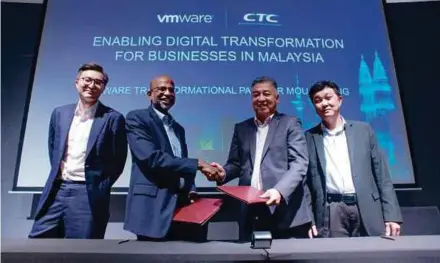  ??  ?? VMware country manager of Malaysia Devan Parinpanay­agam (second from left) exchanging documents with CTC Global Sdn Bhd managing director Dennis Koh at the signing ceremony in Kuala Lumpur recently. With them are VMware Southeast Asia and Korea director, channels and alliances Fan Qu (left) and CTC Malaysia business director Khor Kim Leng.