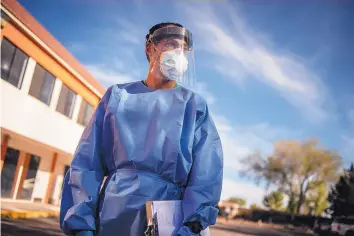  ?? ROBERTO E. ROSALES/ JOURNAL ?? Albuquerqu­e doctor Christian Root-Bowman walks through the parking lot at a Howard Johnson hotel in Gallup at the end of his shift examining patients infected with COVID-19. BELOW: Hotel El Rancho is one of four hotels in Gallup being used to house people who have COVID-19 or have been exposed to the virus and need somewhere to quarantine.