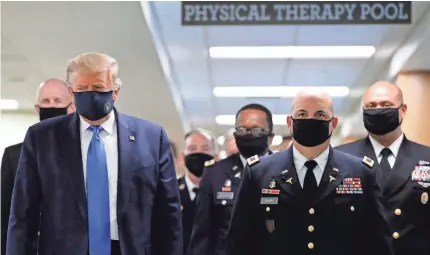  ??  ?? President Donald Trump wears a face mask at Walter Reed National Military Medical Center in Bethesda, Md.