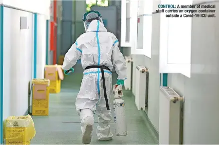  ?? CONTROL: ?? A member of medical staff carries an oxygen container outside a Covid-19 ICU unit.