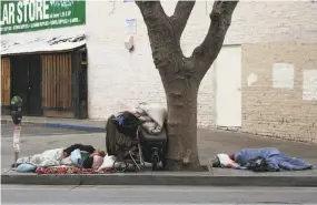  ?? Jim Wilson / New York Times 2016 ?? Homeless people sleeping on a sidewalk near City Hall in San Francisco is a common sight. Propositio­n C is intended to fund solutions for homelessne­ss.