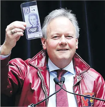  ?? IAN MACALPINE ?? Bank of Canada governor Stephen Poloz wears his 1978 Queen’s Arts and Sciences jacket and holds up a new vertically oriented $10 bill during his speech Tuesday at Queen’s University.