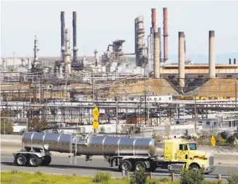  ?? Paul Sakuma / Associated Press 2010 ?? A tanker truck passes an oil refinery in Richmond. Fossil fuels and vehicle emissions are among the leading sources of greenhouse-gas emissions in California and the United States.